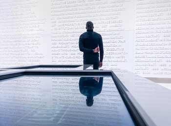 Man viewing an larger than life projected letter on a wall