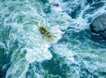 View of a water raft in active, uneasy water