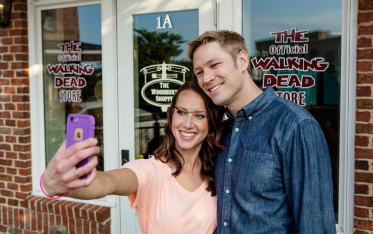 Couple taking a selfie in front of The Woodbury Shoppe in Senoia, Georgia